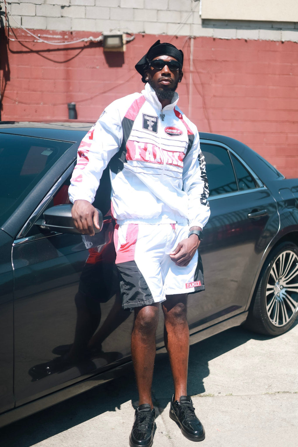 Family Takes Care of Family White Black Red windbreaker set standing by car