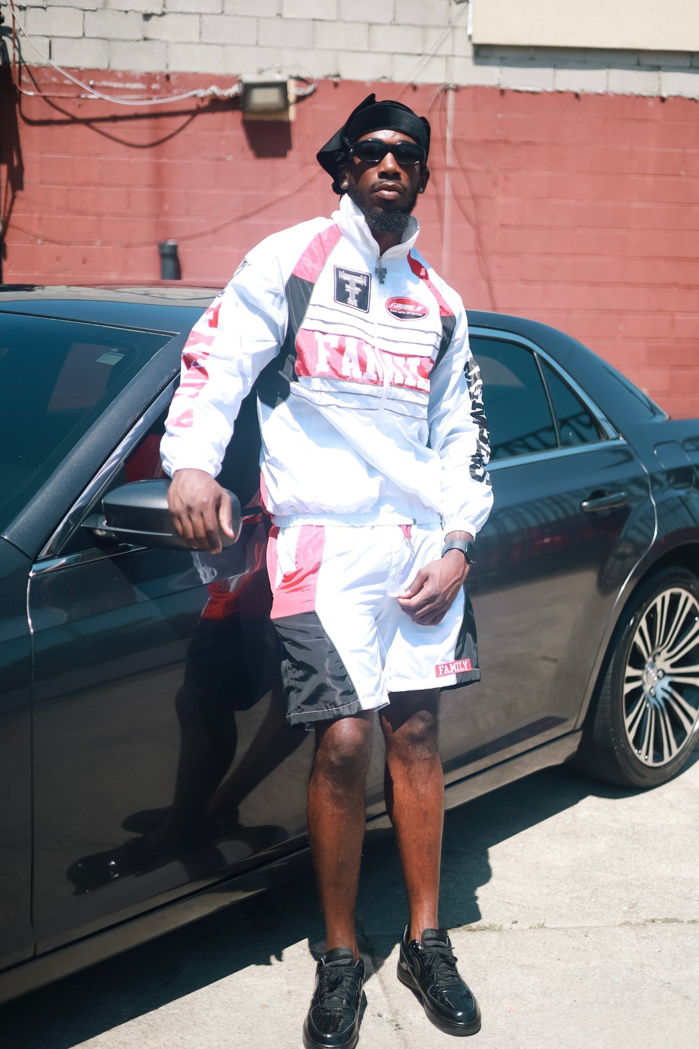 Family Takes Care of Family White Black Red windbreaker set standing by car